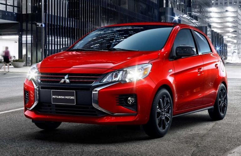 Front angled view of a red 2022 Mitsubishi Mirage on a city road